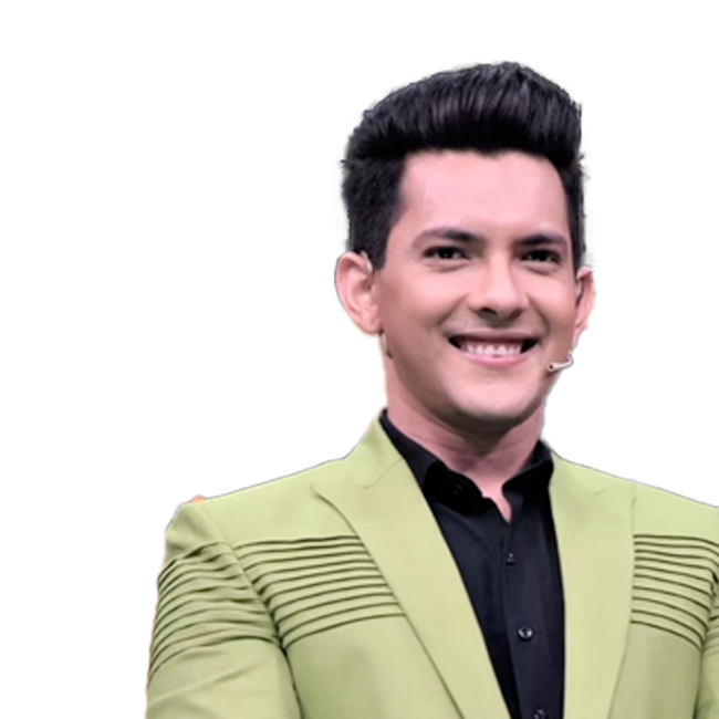  Aditya Narayan smiling, wearing a green blazer and black shirt, with a headset microphone