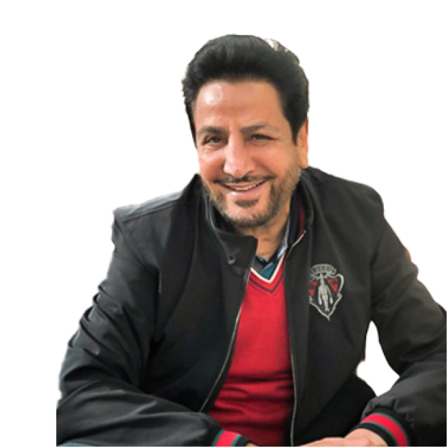 Gurdas Maan smiling, wearing a black jacket and a red sweater.