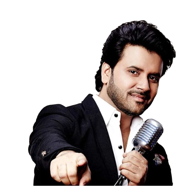 Javed Ali wearing a black suit and white shirt, holding a microphone and smiling.