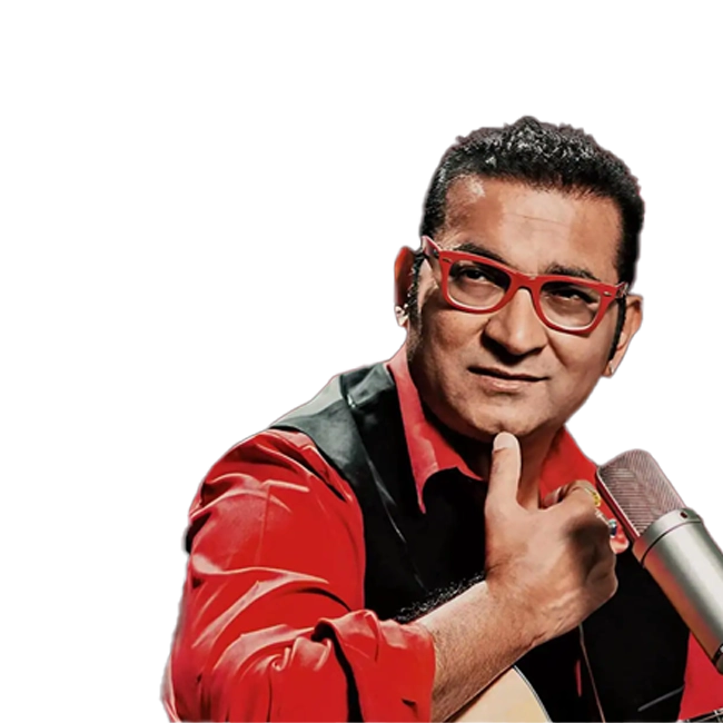 Abhijeet Bhattacharya wearing a red shirt and black vest, singing into a mic.