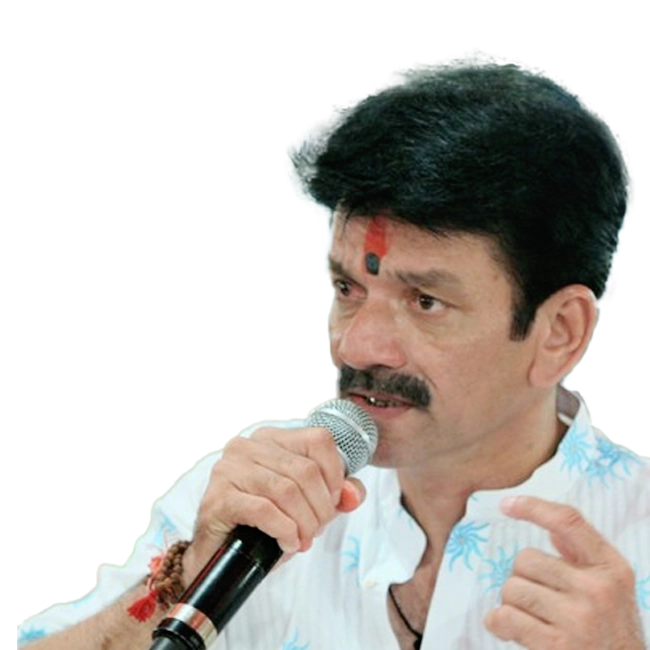 Achal Mehta singing into a microphone, wearing a white shirt with blue patterns and a tilak on his forehead