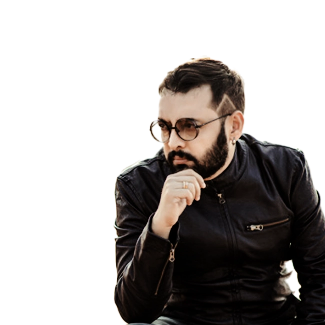 Anoop Sankar wearing a black leather jacket and round glasses.