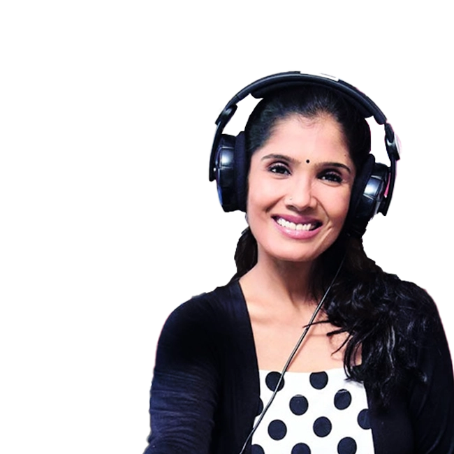 Anuradha Sriram wearing headphones and smiling.