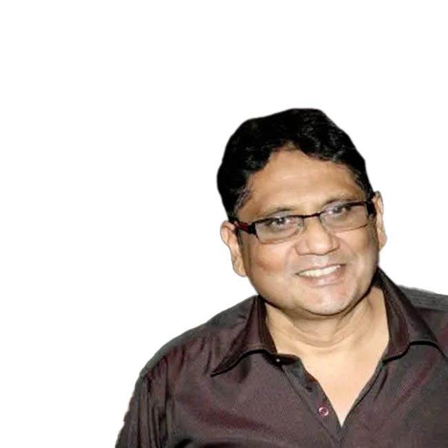 Anwar Hussain smiling and wearing glasses.