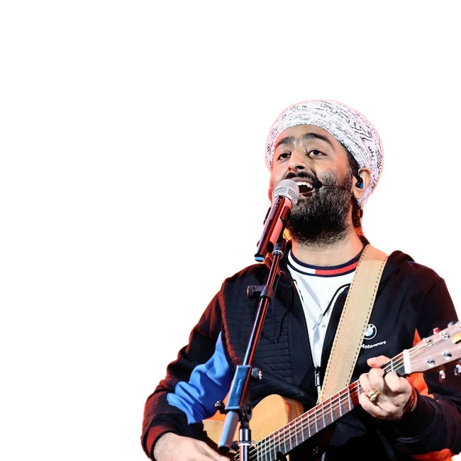 Arijit Singh performing on stage with a guitar and microphone, wearing a black jacket and white patterned headscarf